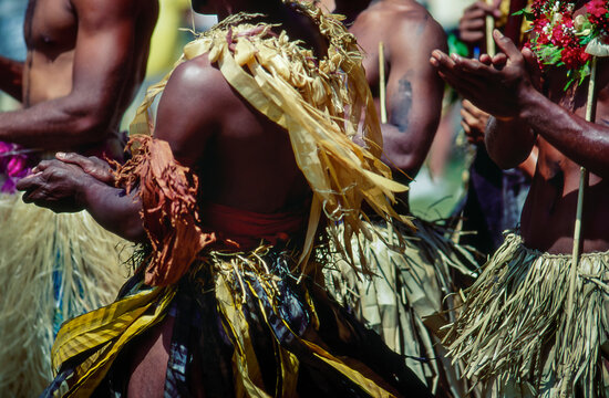 Native Fijian men dressed in traditional dress performing and dancing