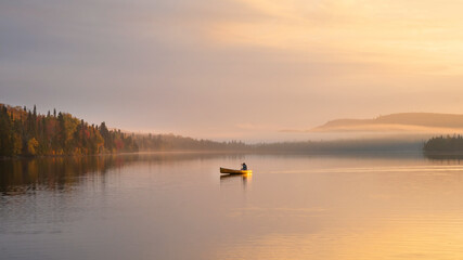 Fototapeta premium People are boating on Caribou Lake on a fogy morning 