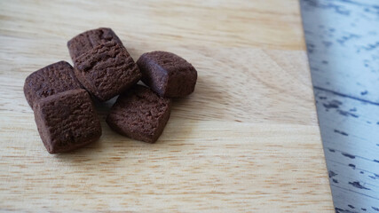 木製の板の上に置かれた濃厚チョコレートクッキーと右側にコピースペースがある写真
