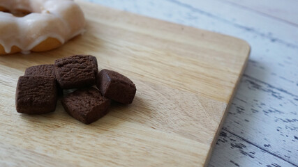 木製の板の上に置かれたシュガードーナツと濃厚チョコレートクッキー