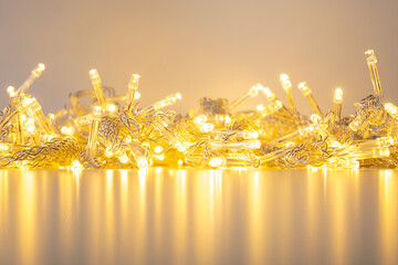golden garland of warm white lights on a table with reflection