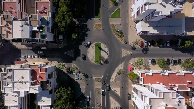 Top-down aerial view of the roofs of the road and streets between small colorful houses in the center of Quarteira, Portugal