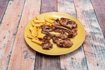 Popular Spanish recipe for fried suckling lamb chops with homemade chips