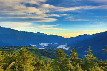 Obraz premium Beautiful landscape of continuously mountains with amazing sky cloud and green trees at dawn 