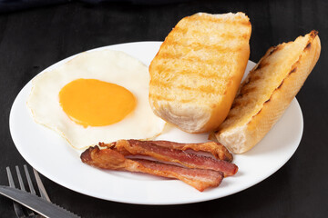 Breakfast with bacon, egg and bread.