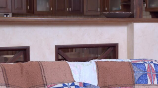 Emotional plump guy in black t-shirt holds cheek by palm shaking head with disappointment and stands up from sofa close view