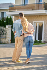 Embracing man and woman looking at house