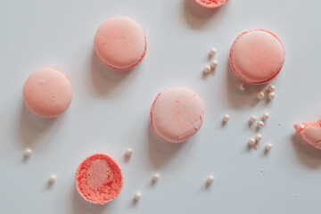 Pink macaron cookies and rose flowers on white background. French cookie. Soft pastel vintage tone. 