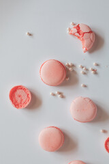 Pink macaron cookies and rose flowers on white background. French cookie. Soft pastel vintage tone. 