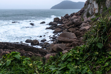 Waves beat against the coastal sea rocks. Coastal sea rocks. Sea rocks view in Brazil