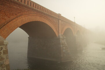 Red brick bridge and mist in Kuldiga, Latvia.
