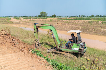 Fototapeta na wymiar Mini excavators are digging soil to lay factory.