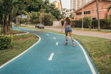 Hispanic young adult woman rollerskating at the park
