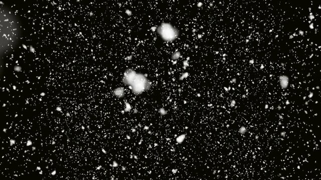 White snow falling on isolated black background