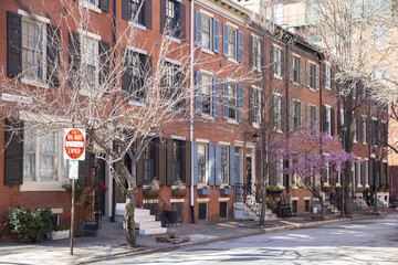 Rows of brownstone apartment buildings in Center City with stoops and planters
