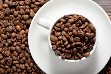 White coffee mug filled with coffee beans