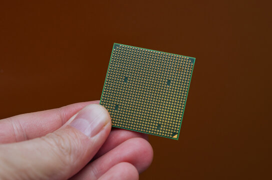 computer processor in hand on orange background