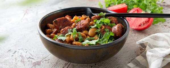 bowl of Basque bean stew with chorizo on the table