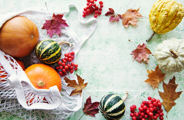Autumn composition with assorted pumpkins in eco string bag