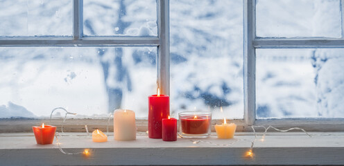 burning candles on a windowsill