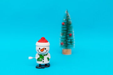 Toy snowman christmas tree on blue background copy space. Merry Christmas and Happy New Year.