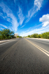 Asphalt road and blue sky with clouds