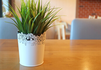Vibrant green artificial potted plant on a dining table