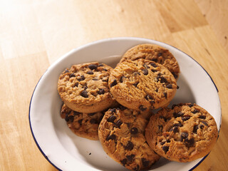 chocolate chip cookies on a wooden table chocolate chip cookies on a pewter plate on a wooden table