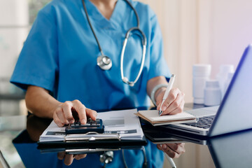 Medical technology concept. Doctor working with mobile phone and stethoscope and digital tablet laptop in modern office at hospital