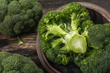 Green fresh broccoli on old wooden background. Ripe vegetables for diet and healthy eating