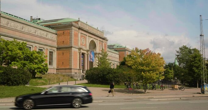View Of National Gallery Of Denmark In Copenhagen With Man And Traffic On Street In Foreground. wide