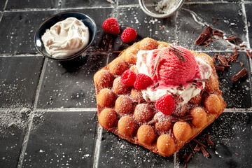 Hexagonal bubble waffle topped with cream ice-cream and berries