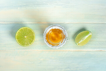 Tequila shot with lime slices, a Mexican drink with a salt rim, overhead flat lay shot with copy...