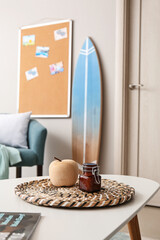 Stylish decor on table and surfboard in interior of room