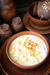 Milk soup on wooden table with pottery tableware