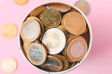 Bowl with golden coins on color background
