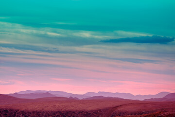 Naklejka na ściany i meble Silhouette of mountain ridge against sunset sky.