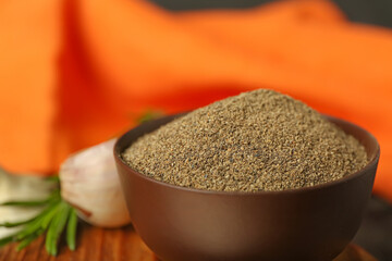 Bowl with black pepper powder on table, closeup