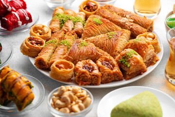 Various Turkish sweets and cup of tea on white textured background