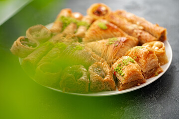 Delicious baklava dessert in oriental setting on black background