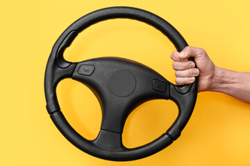 Man holding steering wheel on orange background