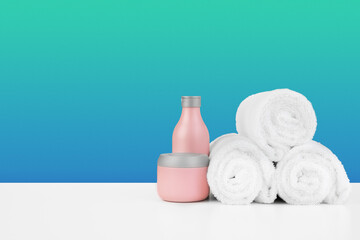 Pile of towels, bottles with shampoo on white table