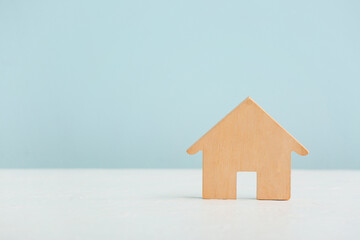 Wooden house on white table against blue background