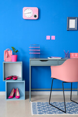 Interior of stylish room with modern workplace and blue wall
