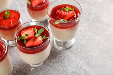 Glasses with delicious strawberry panna cotta and mint on light background