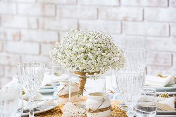 Beautiful table setting with gypsophila flowers in restaurant