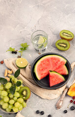 Fruit assortment served on light gray table.