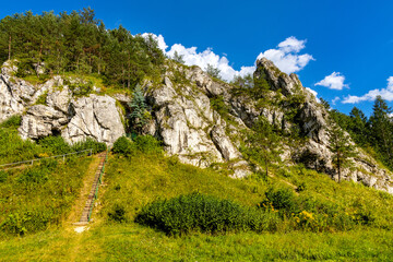 Zabi Kon and Mnich rock with path to Holy Mary cave shrine in Kobylanska Valley within Jura...