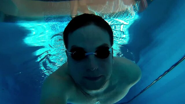 Man Swimming Underwater On Sunny Swimming Pool