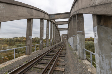 Old railway bridge over the river. Reinforced concrete bridge structure.